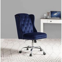 a blue office chair sitting in front of a white desk with a laptop on it