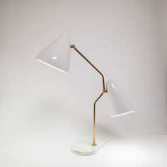 a white table lamp with a gold base