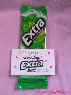 an extra candy bar wrapped in green paper on a pink blanket with a card attached to it