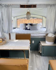 the inside of a camper with a bed and table