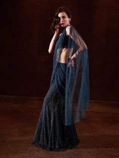 This fully embellished per-stitched sari with a fishtail skirt is paired up with a blouse embroidered with tonal sequins, Crystals and beads. Evening Dupatta With Mirror Work In Traditional Drape, Glamorous Blue Pre-draped Saree, Evening Georgette Sequin Fabric With Traditional Drape, Traditional Drape Sequin Fabric With Mirror Work For Evening, Evening Floor-length Sequin Fabric With Zari Work, Evening Sequin Fabric With Zari Work, Floor-length, Traditional Evening Sequin Fabric With Zari Work, Blue Embellished Evening Dupatta, Embellished Blue Evening Dupatta