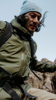 a man sitting on top of a rock next to a mountain