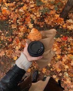 a person is holding a coffee cup and some food