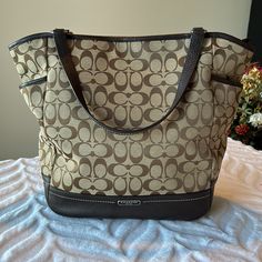 Excellent Condition! Tan Fabric With Dark Brown Leather Trim. Two Side Storage Pockets And One Large Pocket On Back Of Purse With Magnetic Snap Closure. Inside Has One Large Zippered Pouch, One Small Slip Pocket And One Larger Slip Pocket. Top Closes With A Zipper. Storage Bag Included. Smoke And Pet Free Home. Coach Travel Tote Shoulder Bag, Coach Tote Shoulder Bag For Travel, Coach Tan Bag For Everyday Use, Coach Tan Shoulder Bag For Travel, Coach Tan Shoulder Bag For Everyday Use, Coach Tan Bag For Daily Use, Coach Bucket Shoulder Bag For Travel, Zipper Storage, Tan Fabric