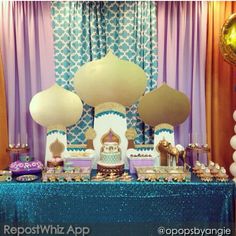 a table topped with lots of desserts and balloons in front of a blue curtain