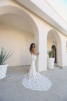 a woman standing in front of a white building