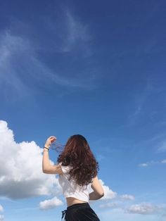 a woman flying a kite in the blue sky