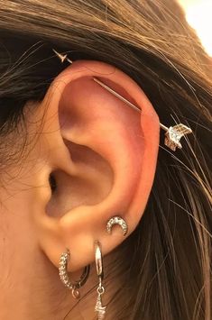 a woman wearing three different ear piercings