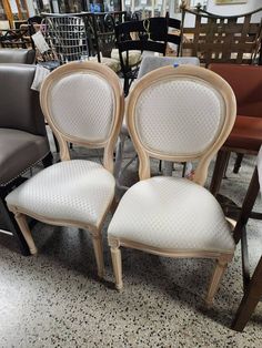 three chairs sitting next to each other on a floor in a room filled with furniture