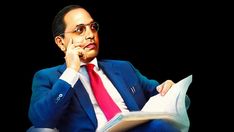 a man in a blue suit and red tie sitting on a chair reading a book