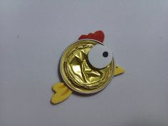 a metal pin with a chicken on it's back and a red heart in the center