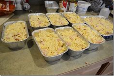 six pans filled with macaroni and cheese sitting on top of a counter