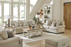 a living room filled with furniture and lots of windows