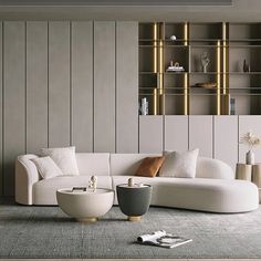 a modern living room with white furniture and gold accents on the walls, along with bookshelves