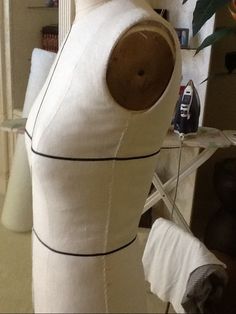 a mannequin made out of white fabric and wood with black lines on it