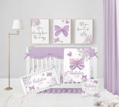 a baby crib bedding set with purple and white butterfly prints on the wall