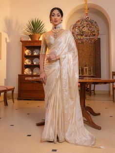 Step into timeless elegance with our Off-White Viscose Satin Silk Saree, a stunning blend of tradition and contemporary allure. Perfect for weddings, festive occasions, or any celebration that demands a touch of sophistication. Crafted from luxurious viscose satin silk, this saree drapes effortlessly, offering a graceful silhouette. The off-white hue complements a variety of skin tones and adds a serene yet regal charm to your ensemble. Pair this saree with its matching off-white satin blouse, which features exquisite embroidery and sequins work. The blouse's delicate embellishments beautifully harmonize with the saree, creating a cohesive and sophisticated look. SAREE SPECIFICATIONS:Fabric: Viscose Satin Silk Adorned with zari motifs along with resham and sequins embroidery lace work on t White Saree Wedding, Satin Sarees, White Sari, White Satin Blouse, Off White Saree, Wedding Wear Saree, Satin Silk Saree, Traditional Silk Saree, Purple Saree