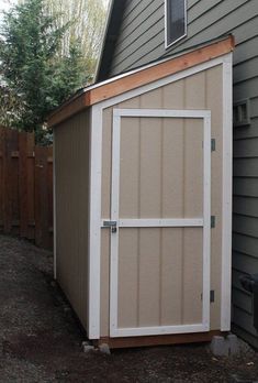 a small storage shed in front of a house