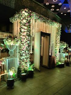 an entrance to a building decorated with flowers and greenery for a wedding or party