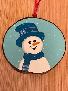 a wooden ornament with a snowman painted on it