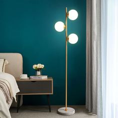 a bedroom scene with focus on the floor lamp and bed in the foreground, against a teal wall