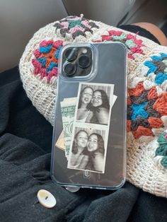 a cell phone case with two photos on it sitting next to a crocheted blanket