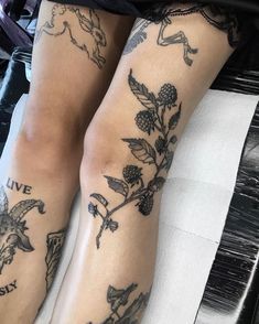 the legs of a woman with tattoos on them are covered in flowers and leaves,