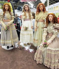 three women dressed in period dress standing next to each other