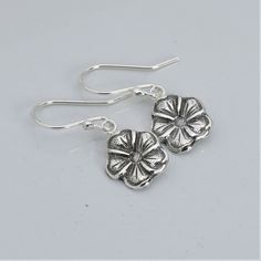 Artisan handmade sterling silver earrings with antiqued finish. Forget me not flower is a symbol of remembrance of a loved one lost. It also symbolizes fidelity, truthfulness, respect and true love. Perfect gift for any woman on her birthday, Mother's Day, anniversary, Christmas holidays, etc. * Dangle length approximately 1 inch * Handcrafted from sheet metal with steel die reproductions and hydraulic press * Antiqued Finish .925 Sterling Silver * Boxed in simple Kraft cotton filled box with ri Sterling Silver Flower Charm Earrings For Anniversary, Handmade Sterling Silver Flower Earrings As A Gift, Handmade Sterling Silver Flower Earrings As Gift For Her, Handmade Sterling Silver Flower Earrings For Her, Sterling Silver Flower Pendant Earrings As Gift, Silver Flower Earrings As Gift For Her, Delicate Sterling Silver Flower Earrings For Gift, Delicate Sterling Silver Flower Earrings As Gift, Delicate Sterling Silver Flower Earrings For Jewelry Making