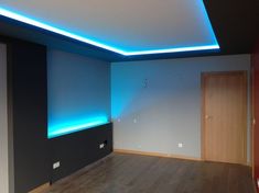 an empty room with wooden floors and blue lighting