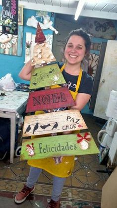 a woman in an apron holding a christmas tree made out of wood