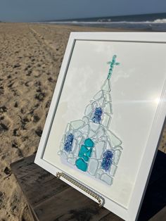 a cross on top of a building made out of ice cubes at the beach