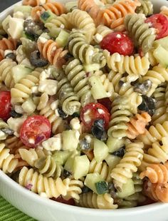 a bowl filled with pasta salad on top of a table