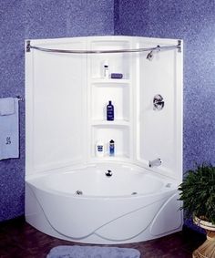 a bathroom with a corner bathtub next to a potted plant and towel rack