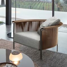 a chair sitting on top of a rug next to a glass table with a lamp