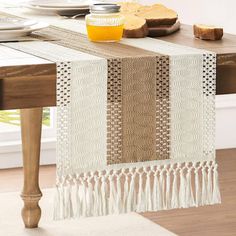 a table runner with tassels on it in front of a dining room table