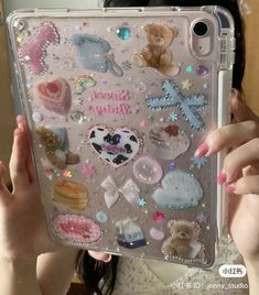 a woman holding up a clear case with lots of stickers on it