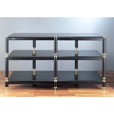 four black shelves with gold handles on each side and one shelf is open to show the contents