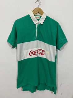 "*ITEM: Vintage Coca Cola Polo Rugby Shirt Medium 1990's Carbonated Usa Drink Coke Soft Drink Green Stripes Polo Shirt Size M *ITEM DETAILS: 👇🏻 Please be aware that all vintage items will usually show a few signs of wear or fading due to age, but anything visible such as stains or holes, and serious flaws have been photographed.For any further information on this item please contact us and we will be happy to help. *SIZE: MEDIUM *ACTUAL SIZE MEASUREMENT: 👇🏻 *PIT TO PIT(WIDTH):20\"INCHES *LEN Vintage Green Collared T-shirt, Retro Collared T-shirt For Streetwear, Retro Collared Cotton T-shirt, Vintage Green Cotton Tops, Retro Green Collared T-shirt, Vintage Green Shirt For Streetwear, Vintage Green Streetwear Shirt, 90s Cotton Collared Tops, Vintage Green Cotton Shirt