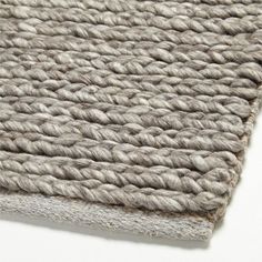 a close up view of a rug on a white surface with grey and beige colors