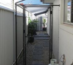 an enclosed walkway with plants in pots and potted plants on the side of it