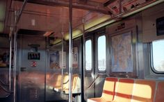 the inside of a subway car with lots of windows and seats on it's sides