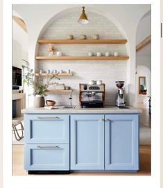 a kitchen with blue cabinets and open shelves