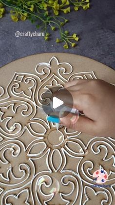 someone is cutting out the design on a cookie sheet with scissors and glues to decorate it