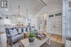 a living room filled with furniture next to a kitchen