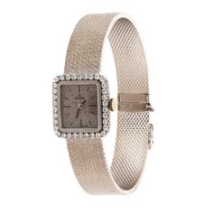 This is a gorgeous Ladies Omega Diamond Watch, in 18K White Gold. The Watch features a Brushed Bark Gold Finish, both on the Watch Straps and the Dial. The Watch showcases a Halo of 34 High Quality, Natural, Round Brilliant Cut Diamonds, totaling 1.15 CTW (F-G-H color; SI clarity), around the Watch Dial. The Watch is Mechanical, and comes from the 1970's - 1980's Era. The Watch measures 7" in Length. It is secured with a Slide Clasp, With Safety Catch, for a secure, worry-free wear. This stunnin Luxury Diamond Watch With Jubilee Bracelet For Evening, Timeless Evening Watches With Single Cut Diamonds, Elegant Formal Watch Accessories: Jubilee Bracelet, Diamond Anniversary Watch With Jubilee Bracelet, Elegant Jubilee Bracelet Watch Accessories For Anniversary, Luxury Jubilee Bracelet Jewelry For Evening, Evening Watches With Jubilee Bracelet And Round Dial, Elegant Diamond Watch For Parties, Diamond Watches With 17 Jewels For Evening