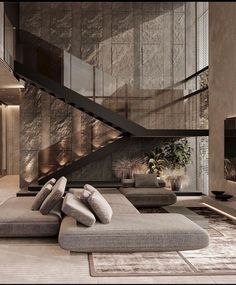 a living room filled with lots of furniture next to a stair case on the wall