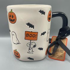 a coffee cup with a halloween theme on it and a tag attached to the mug