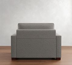 a gray couch sitting on top of a wooden floor