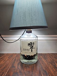 a lamp that is sitting on top of a wooden table next to a glass bottle